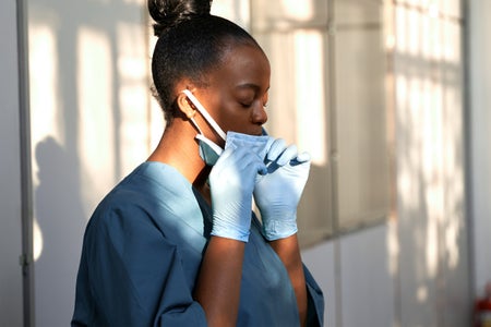 Nurse taking off ger surgican mask