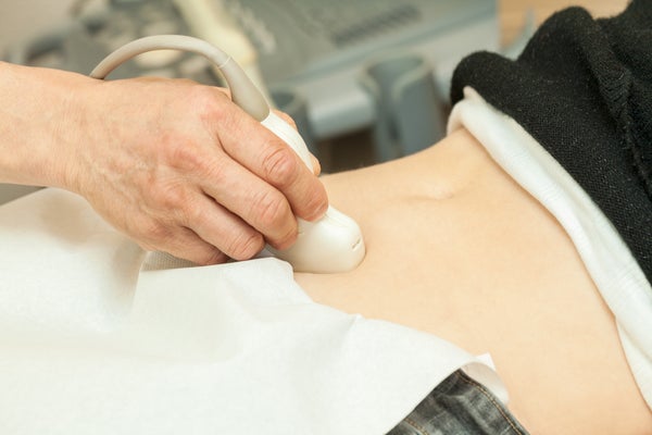 Image of adult woman having abdominal ultrasouClose up of her belly with doctor's hand and ultrasound.