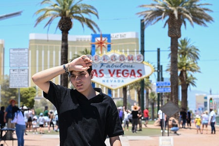 Person reacting to heatwave in front of Las Vegas sign