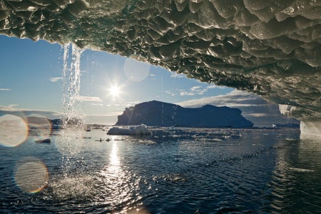 Setting midnight sun lights melting icebergs from Jakobshavn Isfjord along Disko Bay on summer evening.